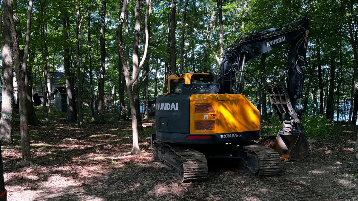 Wooded residential lot with mature trees being cleared for construction