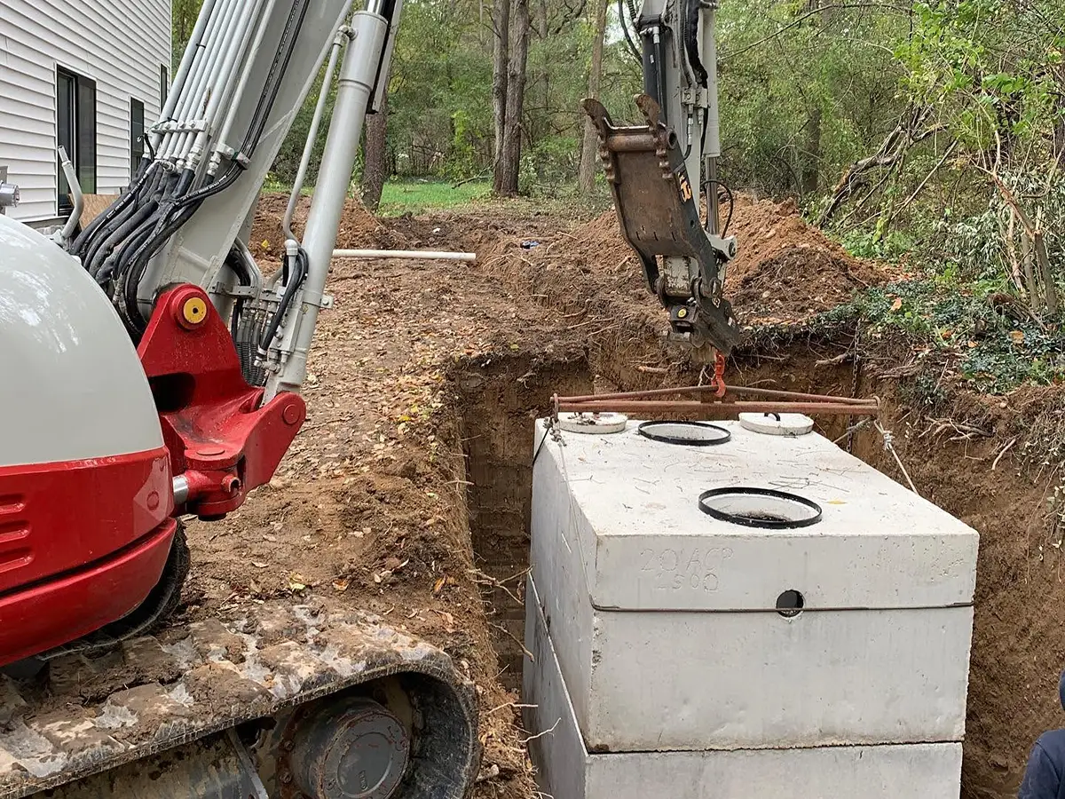 Septic tank being lowered into its excavated position during installation