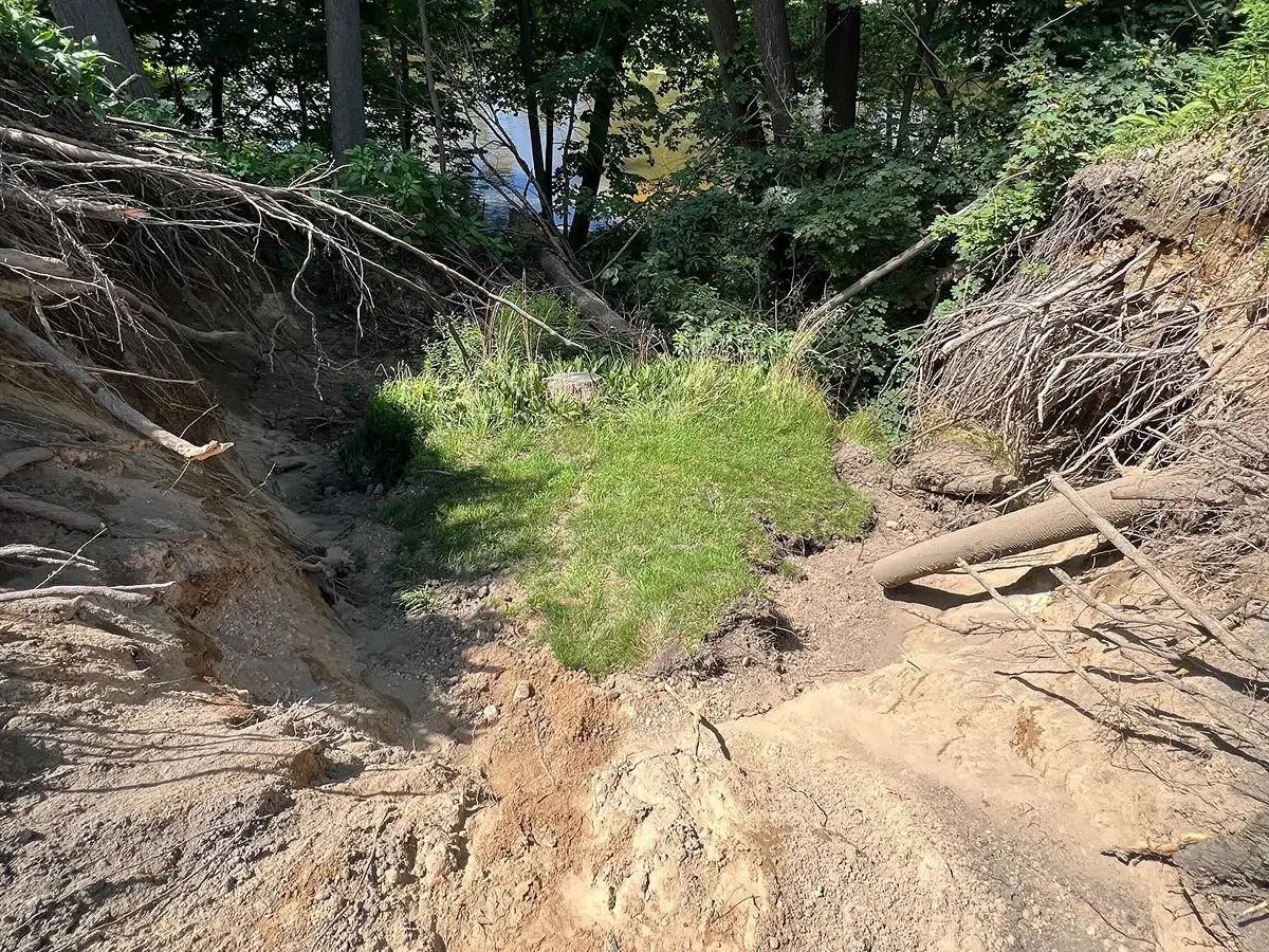 Thornapple River riverbank before erosion restoration showing severe washout damage